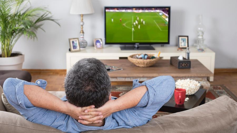 homem assistindo futebol em casa - izzetugutmen/Getty Images/iStockphoto