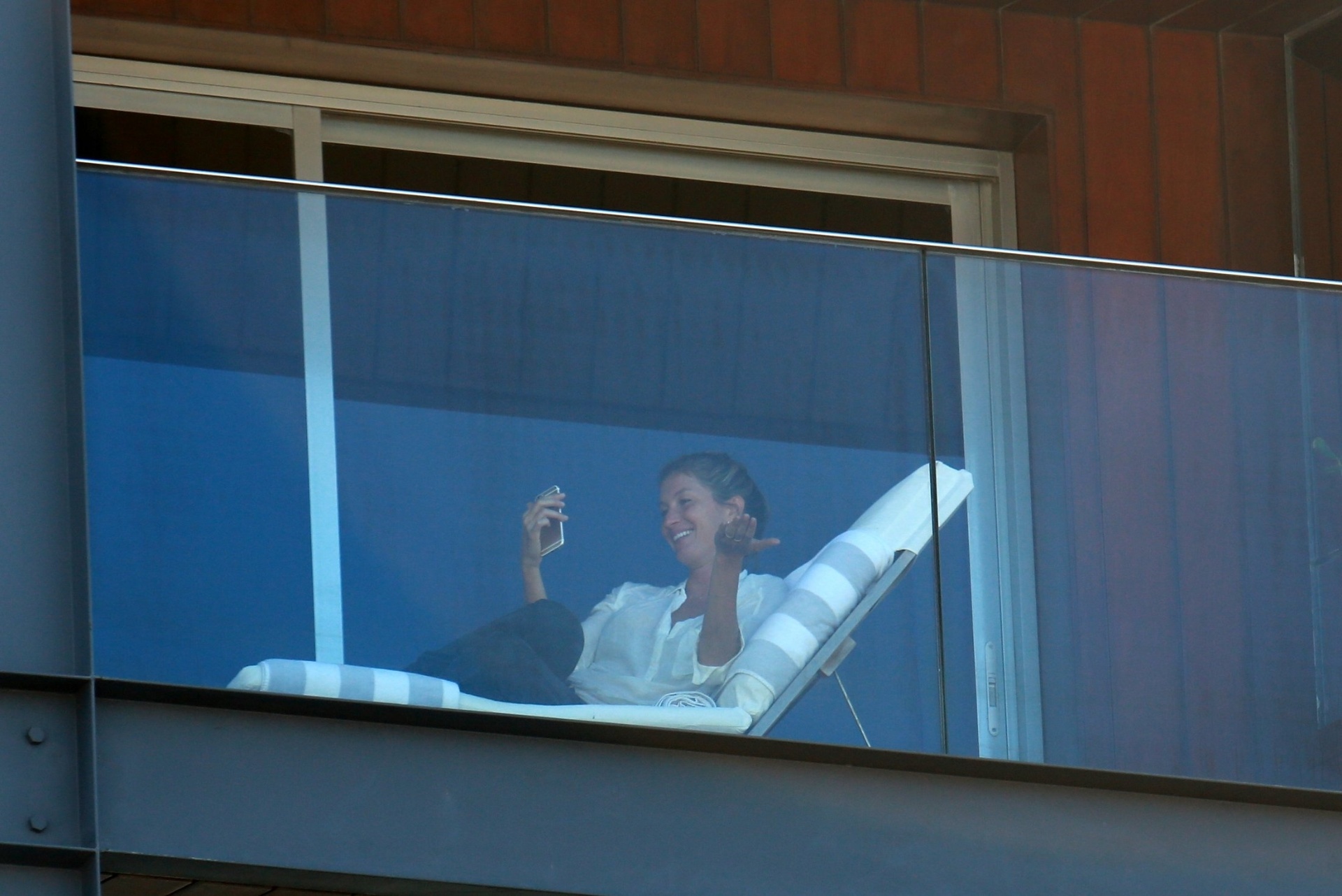 01.ago.2016 - Gisele Bündchen é clicada na sacada do hotel Fasano, no Rio, e parece conversar com alguém no celular. Mais cedo ela desembarcou em São Paulo acompanhada da filhos - Dilson Silva/AgNews