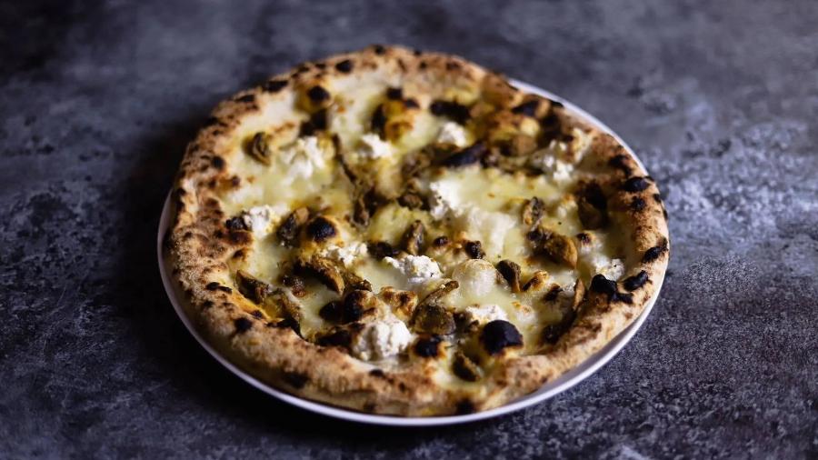 A pizza Umbria, da pizzaria carioca Officina Local, leva cogumelos, alho negro e uma base de queijos brancos A pizza Umbria, da pizzaria carioca Officina Local, leva cogumelos, alho negro e uma base de queijos brancos
