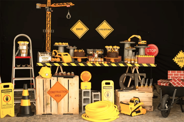 Mais uma opção da Caraminholando é a mesa de cavaletes para o tema construção. Guindaste, placas, palets, tijolos e ferramentas ao redor da estrutura para deixar o cenário completo - Carolina Andrade/Divulgação