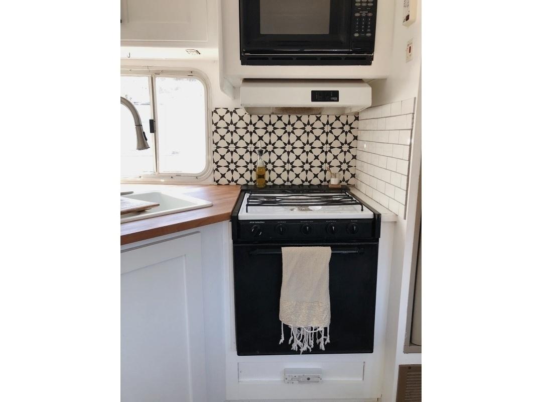 Além de funcional, os moradores também queriam um projeto bonito. Na área do fogão foram aplicados azulejos e ladrilhos, que podem ser autoadesivos, ou fixados com cola específica. Para cozinhar é possível recorrer a um cooktop por indução elétrica ou um fogão a gás. ?No caso do modelo a gás se utiliza um botijão residencial, instalado em compartimento próprio?, comenta Plínio - Ashley Petrone/Divulgação