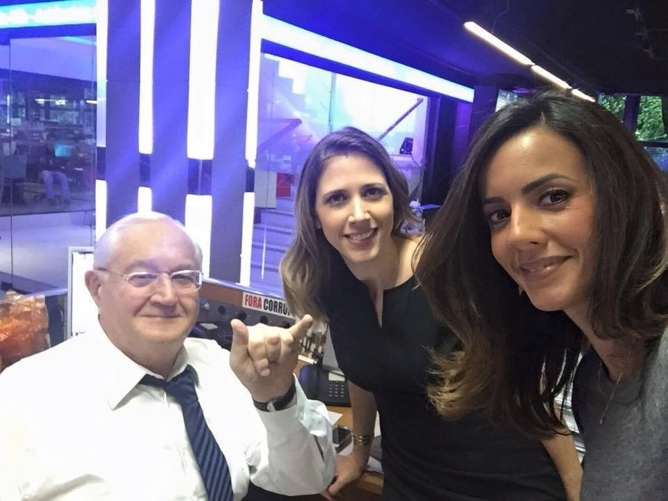 11.jan.2016 - Boris Casoy apareceu bem descontraído antes de apresentar o "Jornal da Band". O jornalista imitou o cumprimento de surfista, com os dedos polegar e mínimo levantados, ao lado das colegas Laura Ferreira e Paloma Tocci - Reprodução/Twitter/laura_ferreira