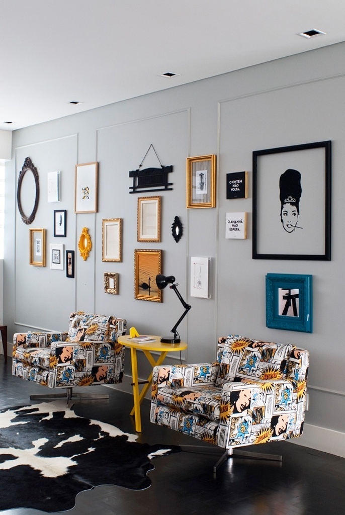 É a cultura das massas que inspira a arte ?pop?. O estilo, surgido nos anos 50, preza por representações pictóricas, figurativas, em cores intensas, de grandes personagens, como atrizes de Hollywood. A D2N Arquitetura e Interiores misturou elementos de apelo vintage com peças coloridas e divertidas ? em detaque, poltronas estampadas de quadrinhos que reproduzem obras de Andy Warhol, além de Audrey Hepburn em Breakfast at Tiffany?s, na parede - Celia Weiss/ Divulgação