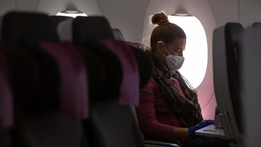 Passageira no avião com máscara - Getty Images/iStockphoto