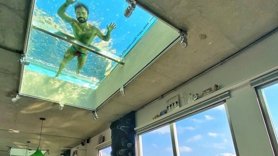 Mauro Sousa posa nadando em piscina que fica no teto da sala da casa dele - Reprodução/ Instagram @maurosousa