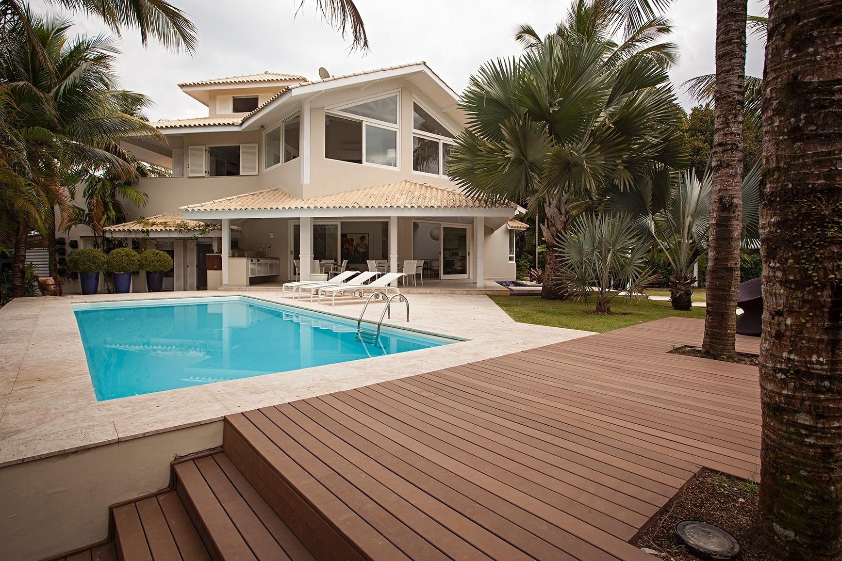 Na casa de praia em Bertioga (SP), o deck que dá acesso à piscina se integra ao jardim. A residência projetada por Korman Arquitetos tem aproximadamente 500 m² e três andares - Divulgação
