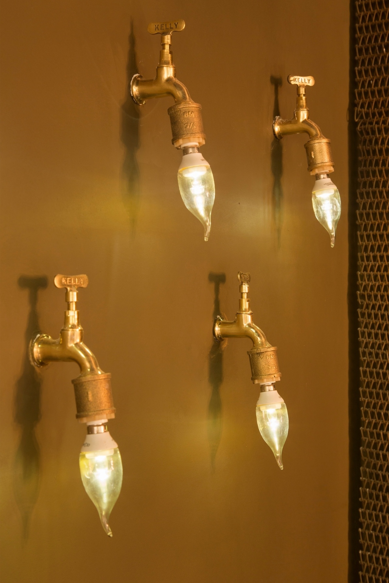 Roberta Jardim e Monique Louzada reutilizaram modelos antigos de torneiras da marca Kelly e criaram inusitadas arandelas para o Espaço Senac, na Morar Mais por Menos RJ. As lâmpadas em formato 'gota' fazem referência ao elemento água e complementam o ar retrô da composição | A mostra (www.morarmais.com.br) fica em cartaz até 2 de novembro de 2015 - MCA Estúdio/ Divulgação