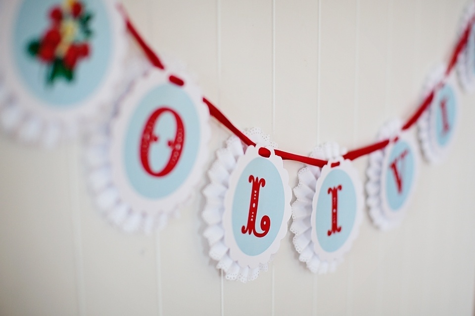 Bandeirinhas de papel com as letras que formavam o nome da aniversariante, Olivia, foram presas a uma corda de tecido e colocadas na mesa principal - Reprodução/Pinterest