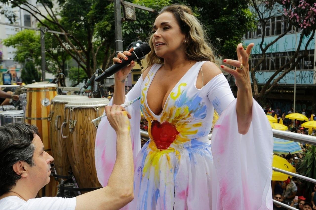 Artista pinta vestido branco de Daniela Mercury durante desfile do bloco Pipoca da Rainha, na rua da Consolação, em São Paulo - Nelson Antoine/UOL