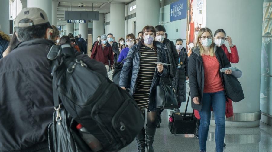 Viajantes com máscara no aeroporto de Pequim - Getty Images