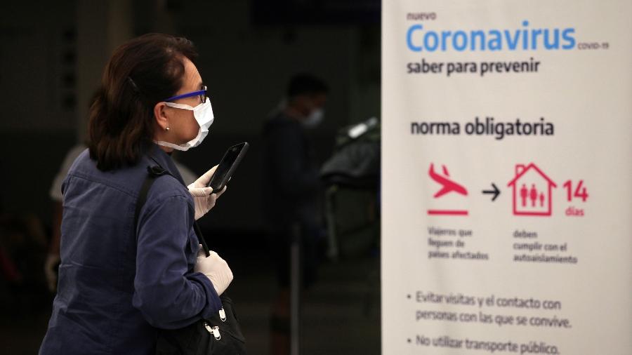 Passageira passa por recomendações contra covid-19 no Aeroporto Internacional de Buenos Aires - Getty Images