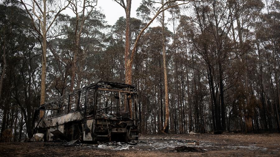 Um ônibus destruído ao lado das queimadas em Mogo, Austrália - Reuters