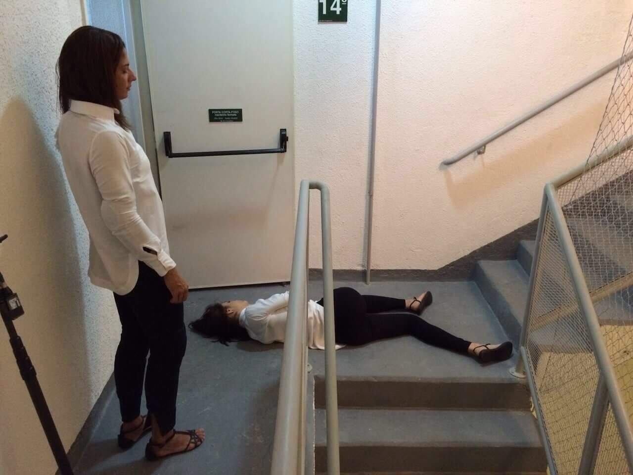 A dublê Monique Venceslau observa Maria Casadevall caída no chão antes de gravar cena de queda da escada para a novela "I Love Paraisópolis" - Reprodução