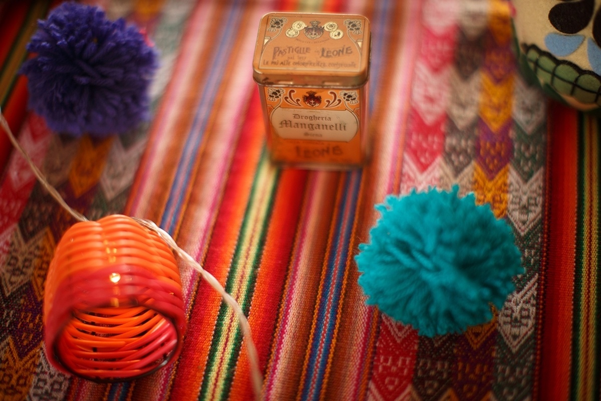 Sobre a manta mexicana, que serviu de toalha na mesa principal desta festa de um ano inspirada em Frida Kahlo, pompons de lã, e cordão de luz decorativo - Ilana Lichtenstein/Divulgação