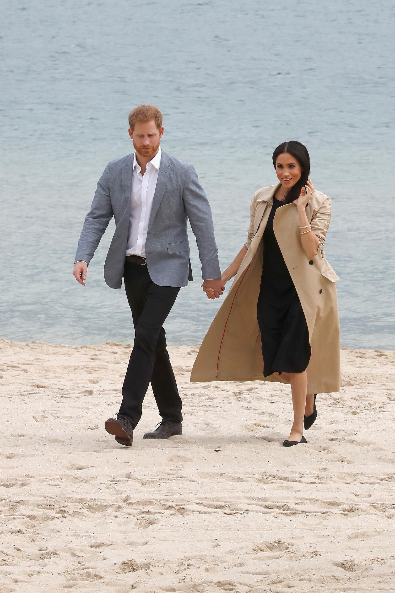 Em uma praia de Melbourne, Meghan deixou o salto alto de lado (inteligente!) e usou uma sapatilha pela primeira vez desde entrou para a família real ? e escolheu um modelo preto da Rothy vendido por 145 dólares (580 reais). O vestido preto é da grife Club Monaco e o trench coat da Martin Grant - Getty Images