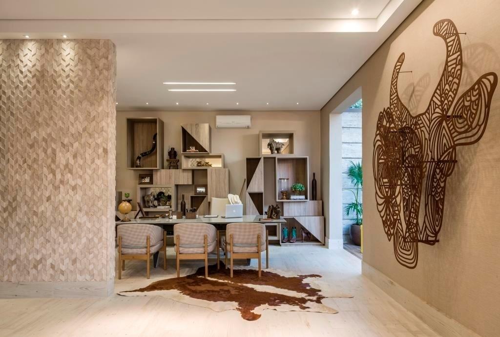 A arquiteta Mariela Romano assina o Loft Fazenda com 103,33 m². Inspirado nas referências rusticais das residências de campo, o espaço conta com paredes revestidas de mármore, uma escultura feita com aço corten (à dir.), tapete de pele de vaca e objetos blocados, como as prateleiras recortadas de madeira (ao fundo) - Jomar Bragança/Divulgação