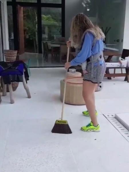 Rafa Brites varrendo a sua casa com o filho no colo - Reprodução/Instagram - Reprodução/Instagram
