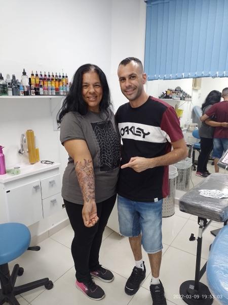 Liliana Oliveira (à esquerda) ao lado do tatuador que fez o desenho em seu braço - Arquivo pessoal