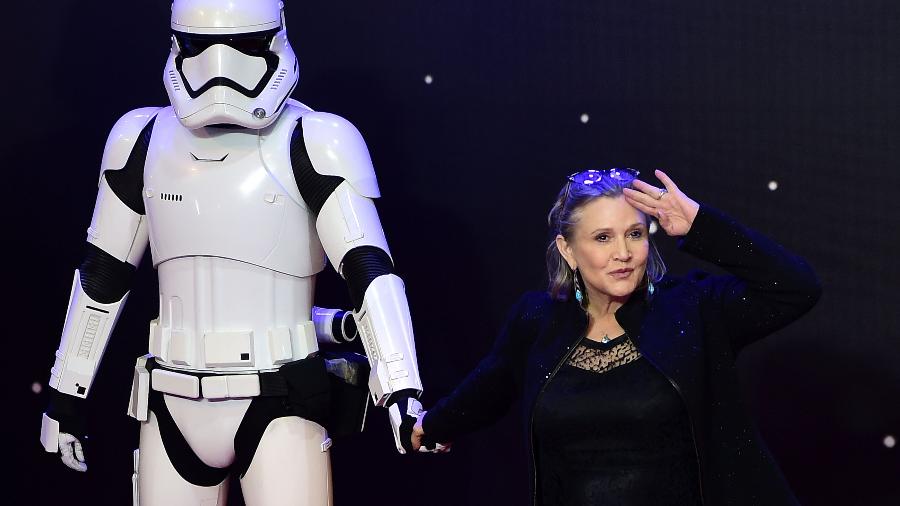 Carrie Fisher posa ao lado de um Stormtrooper durante a pré-estreia de "Star Wars: O Despertar da Força" - AFP PHOTO / LEON NEAL 