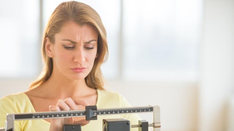 Metabolismo feminino, mulher na balança - iStock - iStock