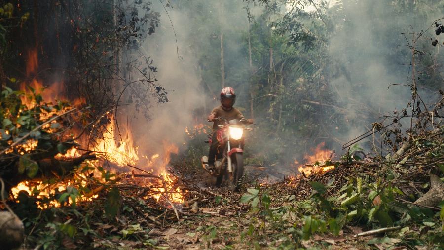 Moto atravessa área de Floresta Amazônica incendiada em Rondônia, em cena do filme O Território - Alex Pritz/O Território/Divulgação