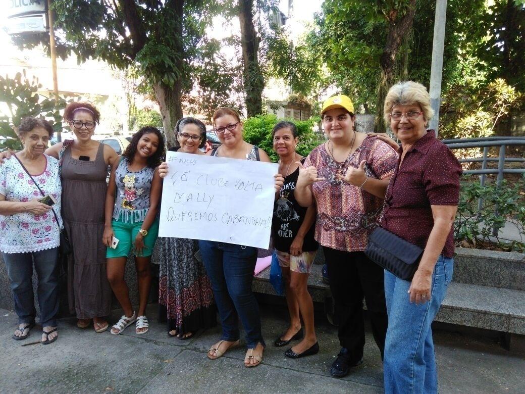 Fãs aguardam pela chegada de Emilly na delegacia da mulher em Jacarepaguá, no Rio, onde a vencedora do "BBB17" prestará depoimento. Ela se envolveu com o médico Marcos no reality, que foi expulso após ser acusado de agredi-la. Alguns dos fãs da gaúcha que pedem pela volta do casal fazem campanha e seguram cartaz com a frase "queremos cabaninha" - Marcela Ribeiro/UOL