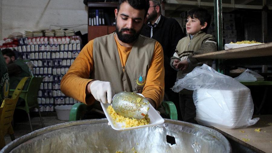 Voluntário serve comida em cozinha comunitária para as vítimas do terremoto na Turquia e na Síria - REUTERS/Firas Makdesi
