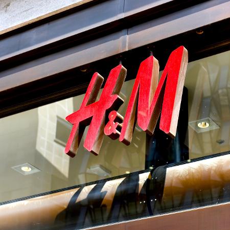 Logotipo da H&M em fachada de loja Logotipo da H&M em fachada de loja