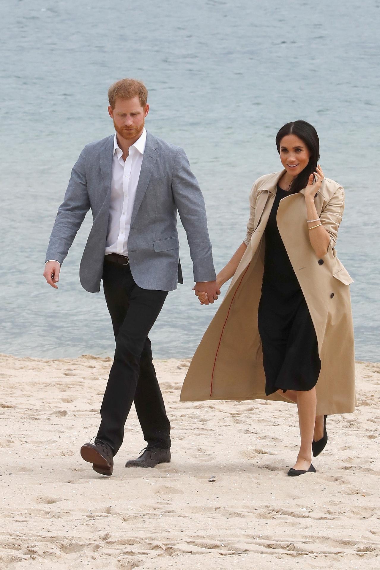 Em uma praia de Melbourne, Meghan deixou o salto alto de lado (inteligente!) e usou uma sapatilha pela primeira vez desde entrou para a família real ? e escolheu um modelo preto da Rothy vendido por 145 dólares (580 reais). O vestido preto é da grife Club Monaco e o trench coat da Martin Grant - Getty Images
