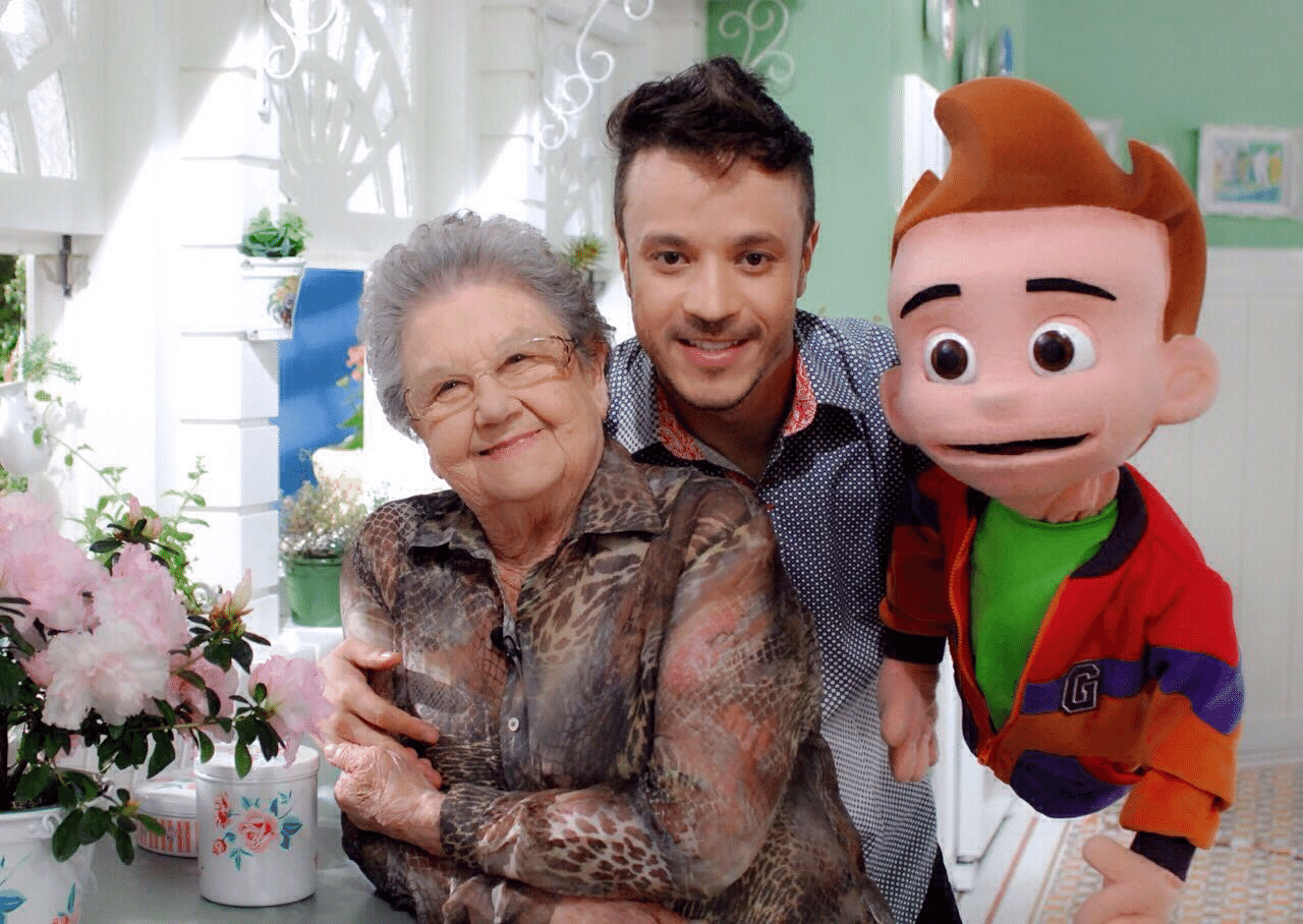 Ajudante de Palmirinha Onofre, Guinho, manipulado por Anderson Clayton, acompanhou a apresentadora em seus programas de culinária na TV Gazeta e no canal pago Fox. Em novembro de 2014, ela rompeu a parceria com Clayton, que além de manipular Guinho era assessor de Palmirinha - Divulgação