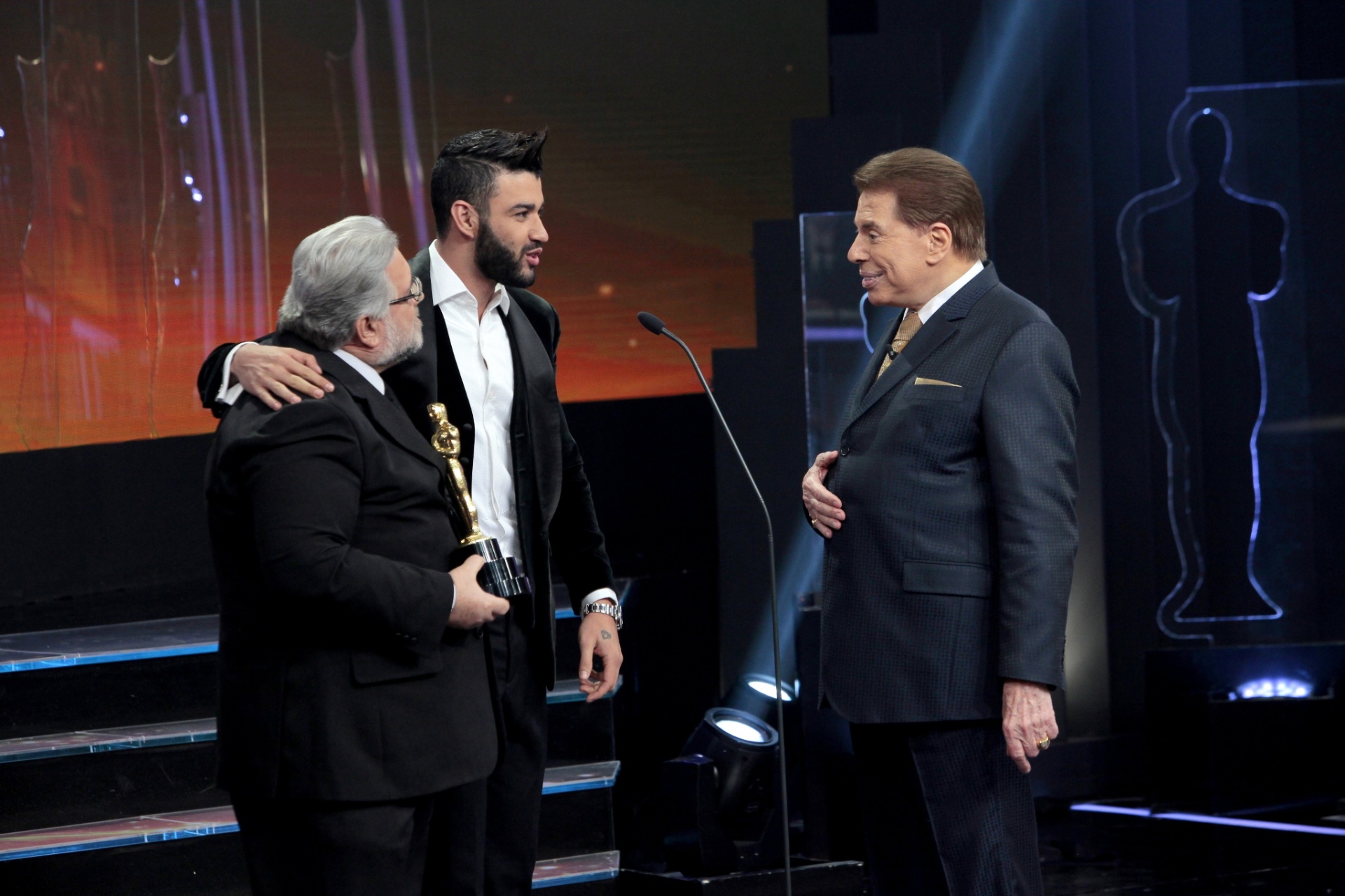 Silvio Santos e o jurado Leão Lobo recebem o cantor Gusttavo Lima no palco do Troféu Imprensa - Divulgação/SBT