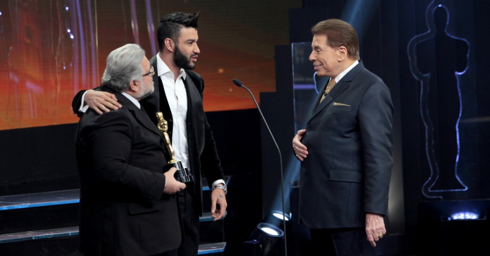 Silvio Santos e o jurado Leão Lobo recebem o cantor Gusttavo Lima no palco do Troféu Imprensa