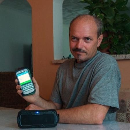 Vlastimil Gular mostra aplicativo que o permite conversar com sua própria voz mesmo após perder sua laringe - Michal Cizek / AFP