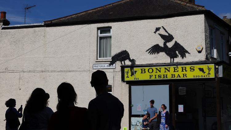 A imagem de dois pelicanos pescando foi pintada por Banksy no muro de um restaurante