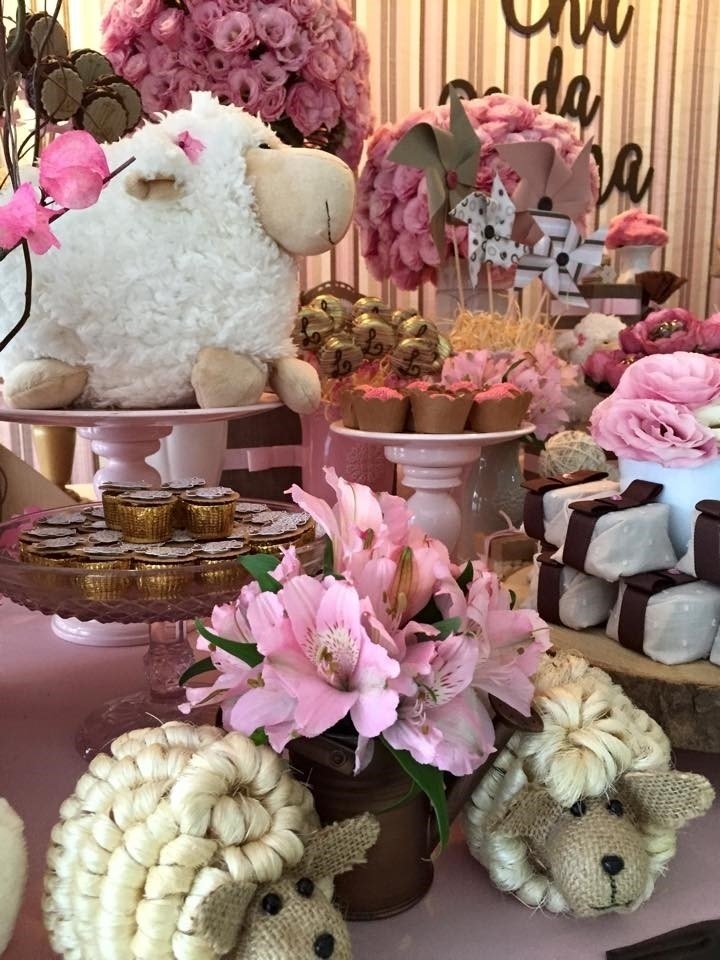 As ovelhinhas de palha sobre a mesa ditaram o tema deste chá de fraldas. Entre elas, minirregador na cor ouro velho com astromélias naturais. Atrás, prato de vidro rosa com chocolates personalizados - Divulgação