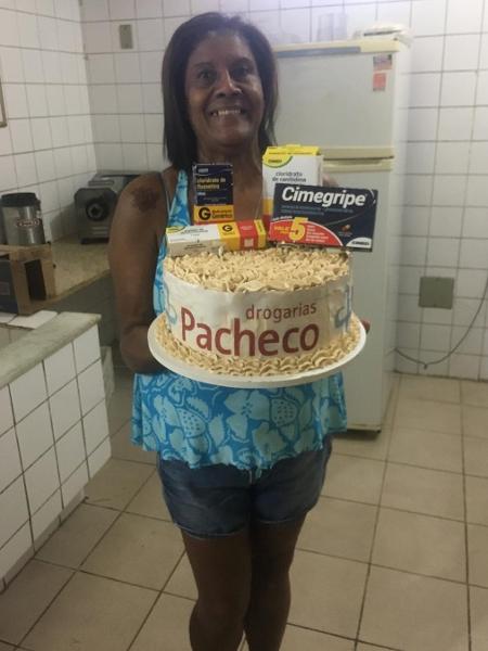 A merendeira Valdecira, 59, com o bolo feito pela filha Cássia, 25 - Arquivo Pessoal