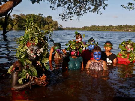 Uyra Sodoma (esq), a drag queen criada pelo artista, ativista e biólogo Emerson Munduruku, posa ao lado de crianças na Amazônia - Ricardo Oliveira/AFP