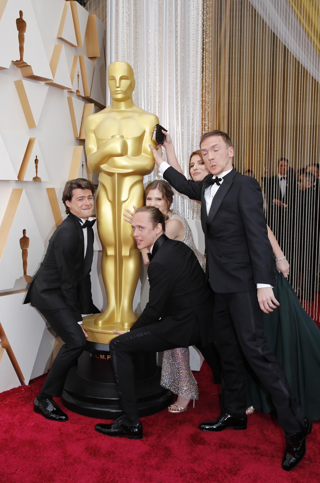 Atores de "Corpus Christi" Bartosz Bielenia, Tomasz Zietek, Eliza Rycembel com o diretor Jan Komasa e convidado brincam com a estatueta no tapete vermelho - REUTERS/Mike Blake