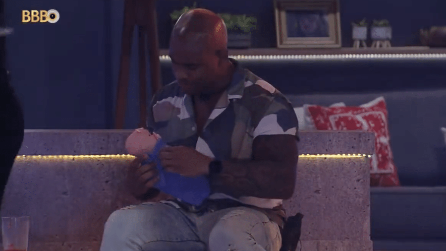 BBB 23: Cezar Black segurando boneca durante a Festa da Líder Bruna - Reprodução/Globoplay