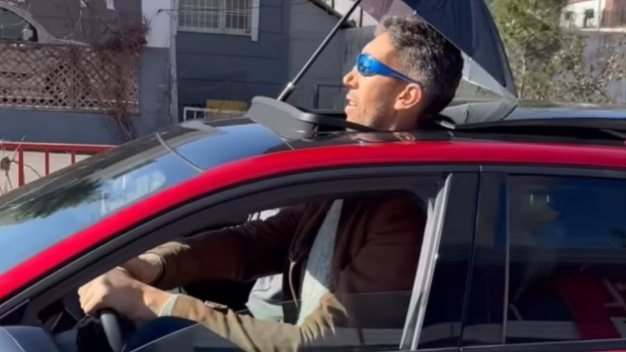 Homem mais alto do mundo guia carro com teto solar aberto