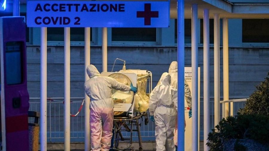 Em Roma, profissionais de saúde carregam paciente em tratamento intensivo para um hospital recém-construído  - ANDREAS SOLARO/AFP via BBC