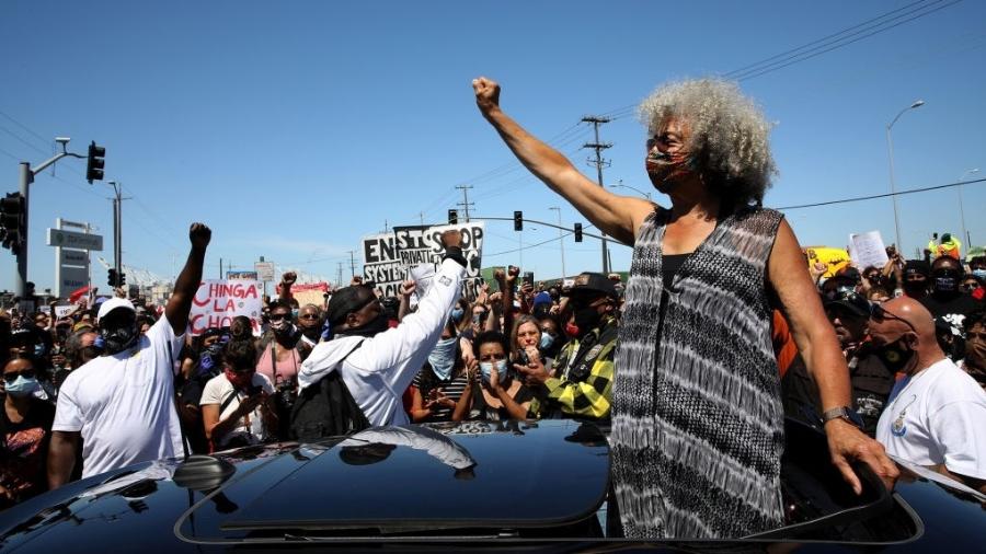 2020: Angela Davis ergue o punho em solidariedade durante um protesto de 19 de junho contra a brutalidade policial. Estivadores fecharam o porto de Oakland, na Califórnia, e 28 outros portos ao longo da costa oeste - San Francisco Chronicle/Hearst N/Hearst Newspapers via Getty Imag