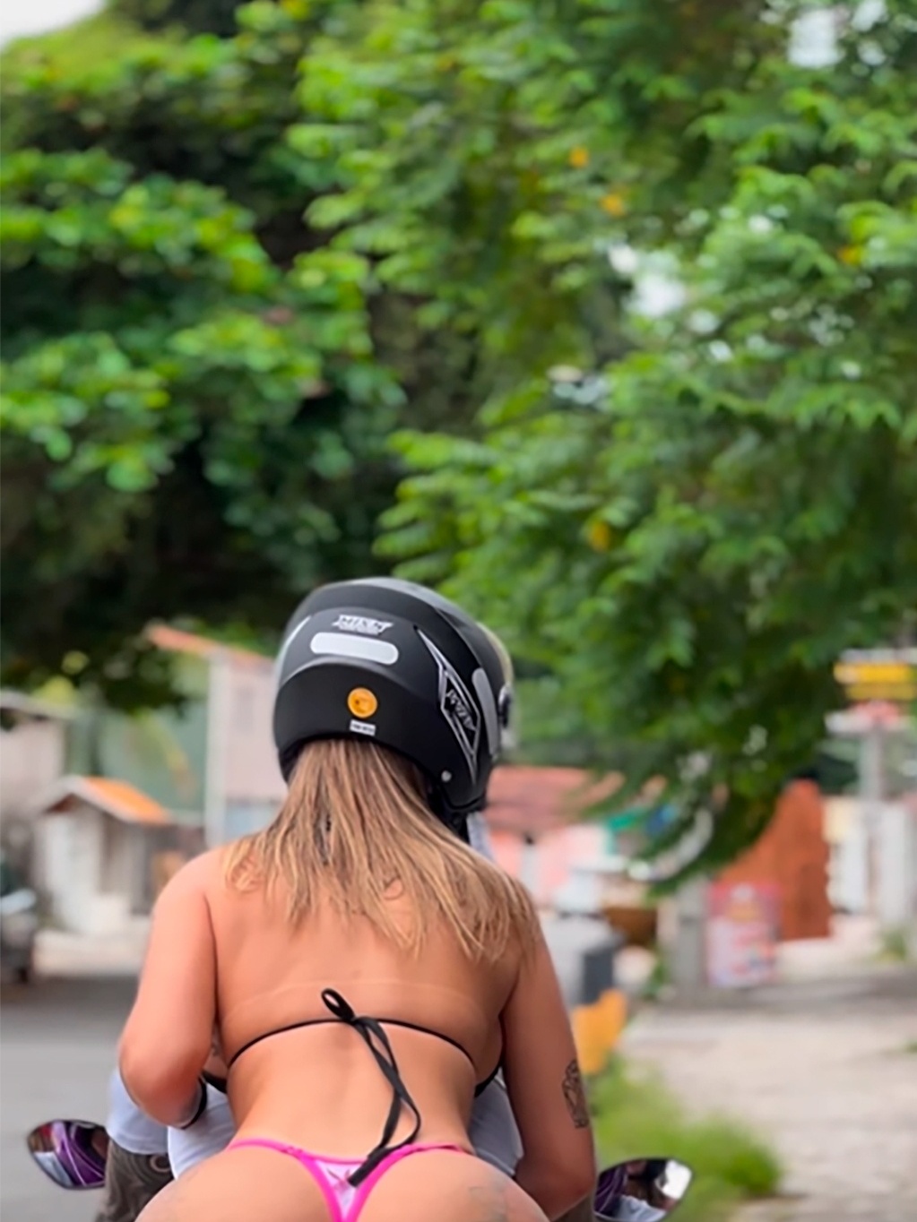 Passageira de biquíni pode? Influencer chama atenção ao pilotar moto