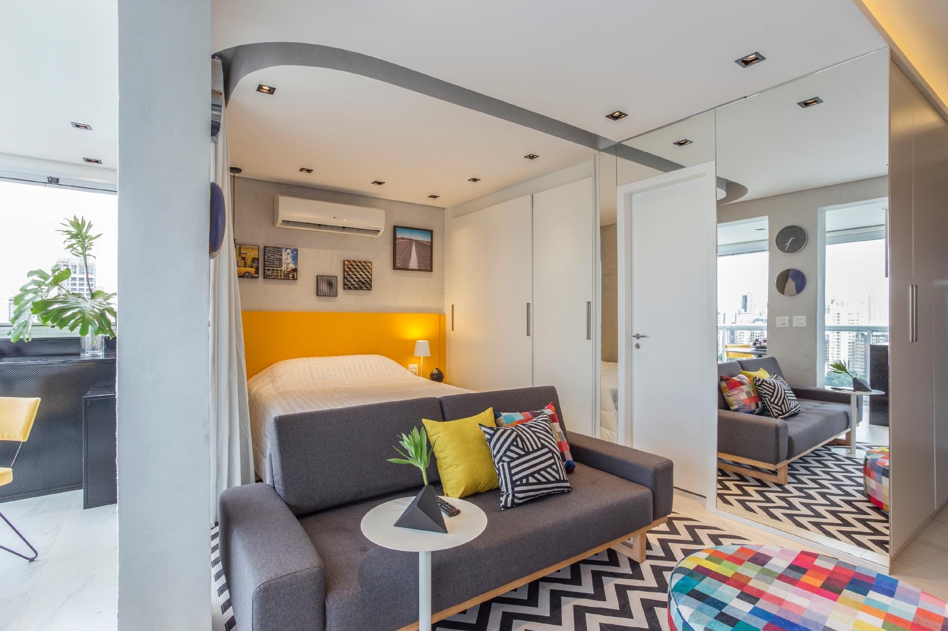 Em espaços pequenos e integrados, sempre convém assegurar iluminação natural e transmitir sensação de amplitude. Miyahara recorreu ao espelho, aproveitando a parede vazia em torno da porta, não só com esse objetivo, assim como para atender os usuários na área dos armários - Maura Mello/Divulgação