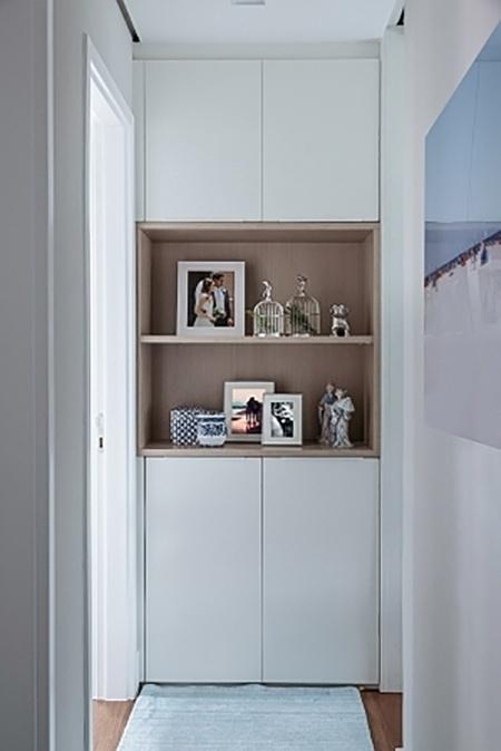 No final do corredor, entre as portas laterais, havia um recuo que não tinha finalidade alguma. Com pouco espaço para armazenar roupas de cama, a arquiteta Ana Yoshida utilizou o vão justamente para criar um armário, que ainda dispõe de nichos para decoração - Evelyn Müller / Divulgação