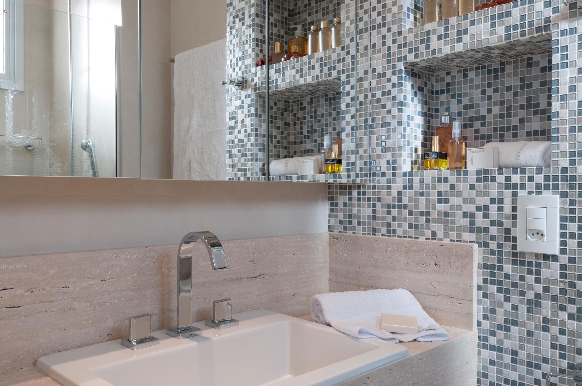 Com apenas 2,50 m² e cores neutras, esse banheiro esbanja aconchego e bem-estar. Para quebrar a sobriedade dos acabamentos principais, a arquiteta Cristiane Schiavoni apostou no mosaico de pastilhas coloridas. Outra boa ideia: o armário com porta espelhada organiza os itens de higiene, já os nichos deixam à vista cremes e perfumes - Raul Fonseca | Divulgação