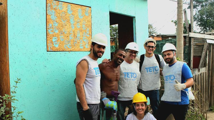 Laerte, conhecido como "Perninha", ao lado dos voluntários em frente à sua nova casa. - Jonathan Ferreira da Silva e Juliana Miller Gomes/TETO - Jonathan Ferreira da Silva e Juliana Miller Gomes/TETO