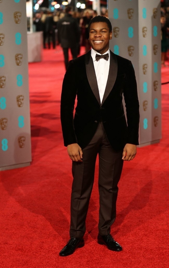 14.fev.2016 - Ator britânico John Boyega posa sorridente no tapete vermelho da premiação - AFP