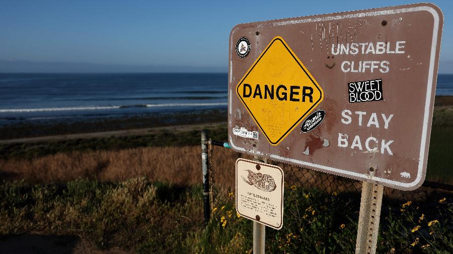 Placa na praia de Trestles mostra mensagem avisando sobre perigo de instabilidade no terreno Placa na praia de Trestles mostra mensagem avisando sobre perigo de instabilidade no terreno