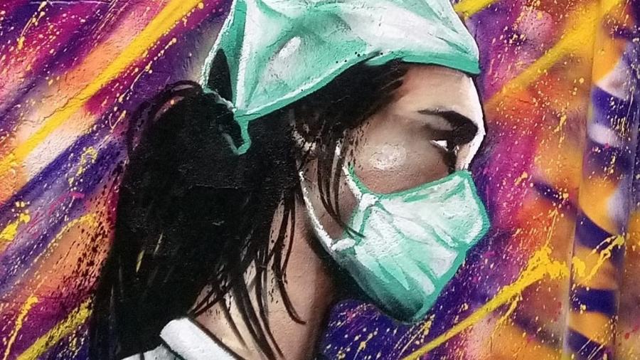 No distrito da Brasilândia, o grafiteiro Digão pintou o rosto de uma amiga enfermeira em um muro, e colocou máscaras em retratos antigos - Arquivo Pessoal